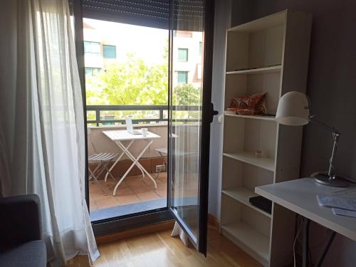um quarto com uma porta de vidro que leva a uma varanda em Acogedor y tranquilo em Valladolid