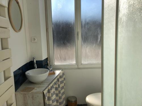 uma casa de banho com um lavatório e uma janela em Maison de famille em Saint-Mars-dʼOutillé