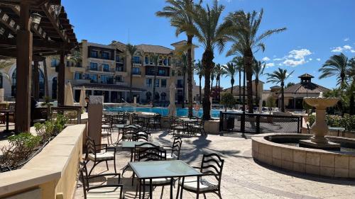 eine Terrasse mit Tischen und Stühlen vor einem Hotel in der Unterkunft Apartment in Mar Menor Golf Resort in Torre-Pacheco