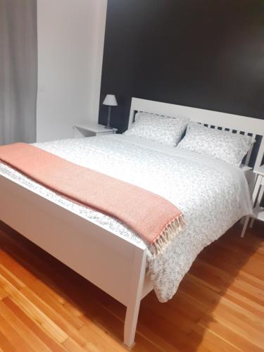 a bedroom with a white bed with a orange blanket at Bressa de Ma affittacamere, room & breakfast in Pietra Ligure