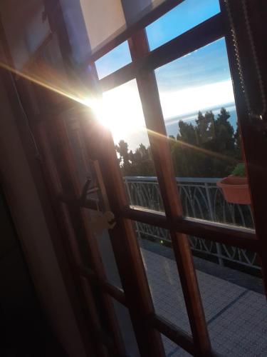 a door to a balcony with the sun shining through at Bressa de Ma affittacamere, room & breakfast in Pietra Ligure