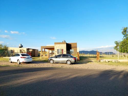 dos autos estacionados frente a una casa en Cabaña Villa Emocion in 