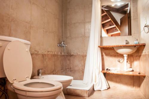 y baño con aseo, lavabo y ducha. en La Aljaba en San Carlos de Bariloche