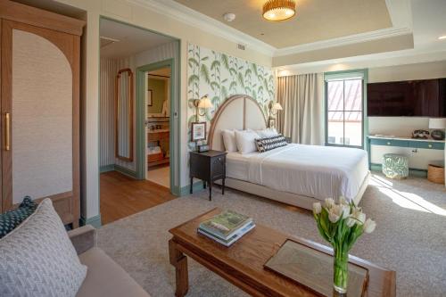 a bedroom with a bed and a living room at The Palmetto Hotel, Charleston in Charleston