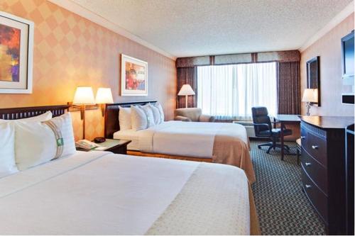 a hotel room with two beds and a desk at Holiday Inn Diamond Bar - Pomona, an IHG Hotel in Diamond Bar