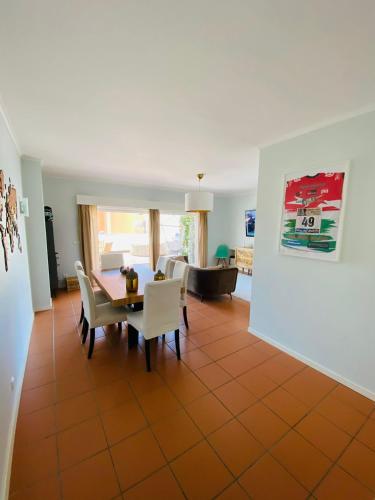 a dining room and living room with a table and chairs at Rooms Cabedelo Beach Loft in Darque