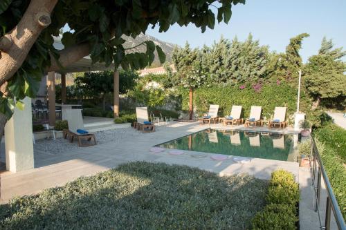 a backyard with a swimming pool with chairs and a table at IRIDA in Koilás
