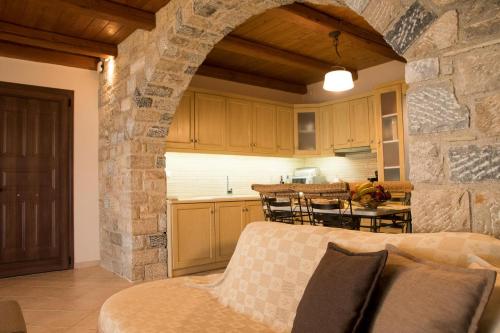 a kitchen and a living room with a stone wall at IRIDA in Koilás