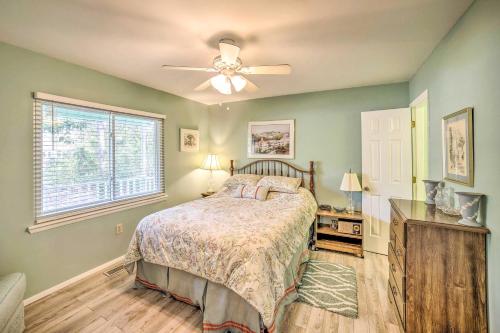 um quarto com uma cama e uma ventoinha de tecto em Oak Island Home with Yard Less Than 1 Mi to the Beach! em Oak Island