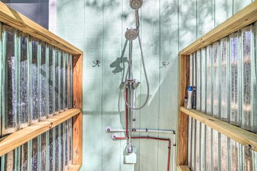 Una ducha en una habitación con paredes de madera. en Oak Island Home with Yard Less Than 1 Mi to the Beach!, en Oak Island