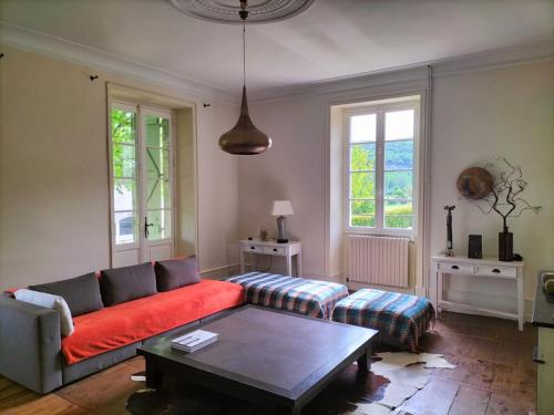 un salon avec un canapé rouge et une table basse dans l'établissement Vakantiehuis Domaine de Nazac, à Saint-Sulpice