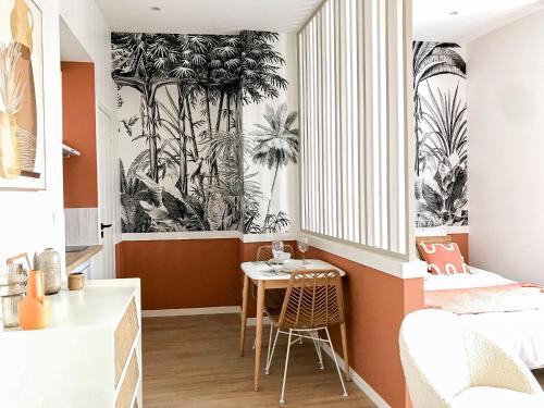 Pokój ze stołem i sypialnią z tapetą z palmami w obiekcie Le Terracotta - Superbe appartement - Hyper centre w mieście Le Mans