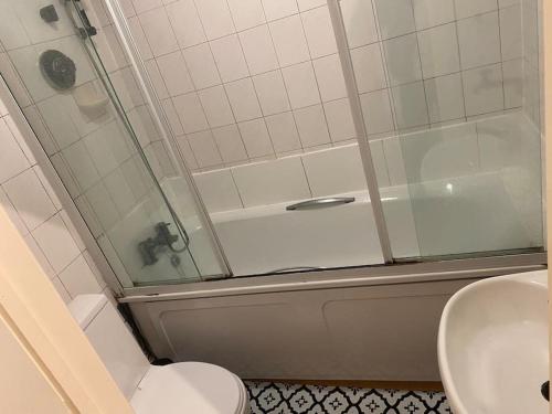 a bathroom with a shower and a toilet and a sink at Cosy Studio West Hampstead in London