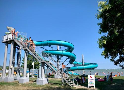 a water slide at a beach with people on it at RÉKA háziállatbarát nyaraló in Keszthely