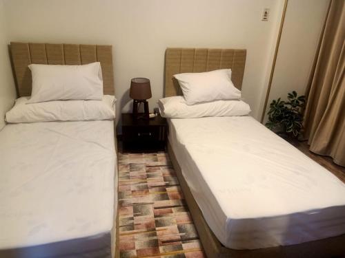 two beds sitting next to each other in a room at فاكانزا شقة فندقية مفروشة- vacanze in Fayoum Center