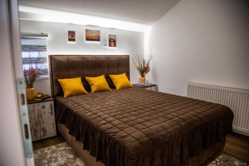 - une chambre avec un grand lit et des oreillers jaunes dans l'établissement Smile, à Pirot