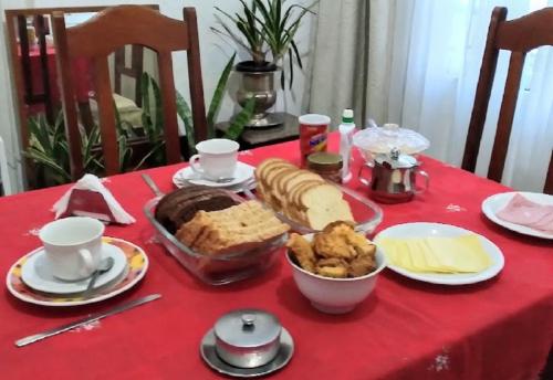 una mesa con un mantel rojo con comida. en Casa da vó, en São Gabriel