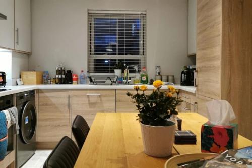 una cucina con tavolo e vaso di fiori di 3 Bedroom Townhouse, Free Parking a York