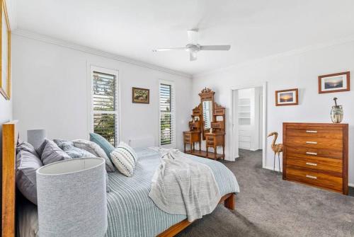 ein weißes Schlafzimmer mit einem Bett und einer Kommode in der Unterkunft Tara's Place Lake Views in Yarrawonga