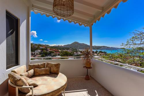 a balcony with a chair and a view of the ocean at The Pink Palm Hotel - Adults Only in Charlotte Amalie