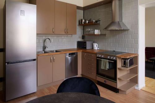 a kitchen with a stainless steel refrigerator and a sink at Best Western Hotel Baltic in Sundsvall