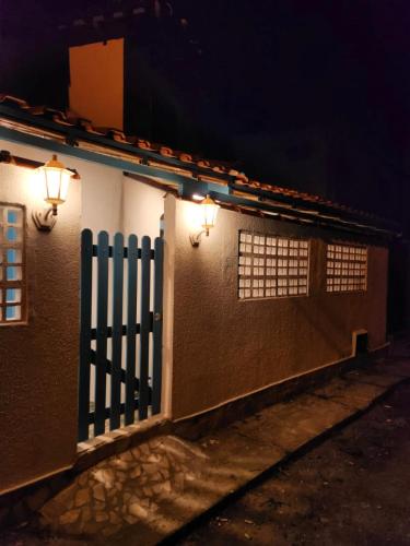 a house with a fence and lights on it at Casinha Azul Ilha Grande in Abraão