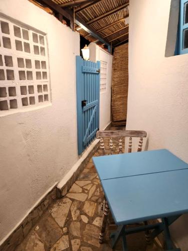 a blue table in a room with a blue door at Casinha Azul Ilha Grande in Abraão