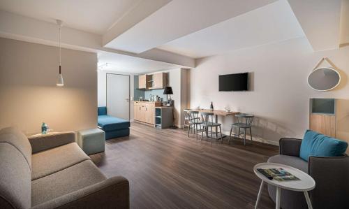 a living room with a couch and a table at elaya hotel oberhausen in Oberhausen