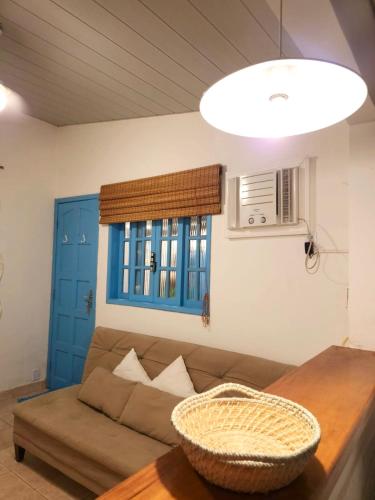 a living room with a couch and a table at Casinha Azul Ilha Grande in Abraão