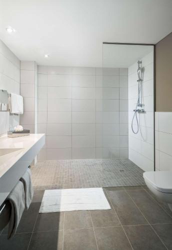 a bathroom with a shower and a sink and a toilet at elaya hotel oberhausen in Oberhausen