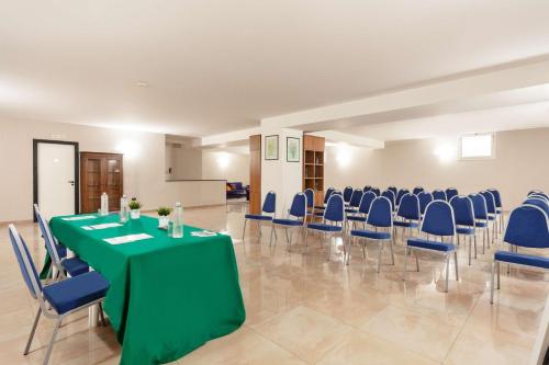 a conference room with a green table and blue chairs at Best Western Hotel Imperiale in Nova Siri Marina