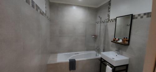 a bathroom with a bath tub and a sink at Chai & Spice Guesthouse and Café in George