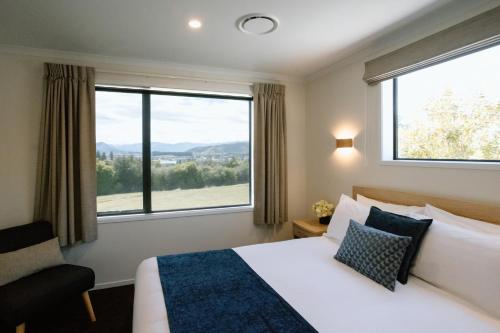 a hotel room with a bed and a large window at Wanaka Top 10 Holiday Park in Wanaka