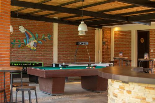 a room with a pool table and a brick wall at Hotel & Glamping Huasca Sierra Verde in Huasca de Ocampo