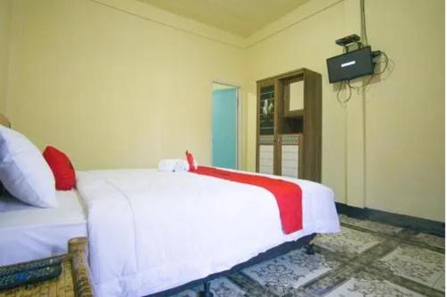 ein Schlafzimmer mit einem Bett und einem TV an der Wand in der Unterkunft MURSYS PLACE in Kuta Lombok