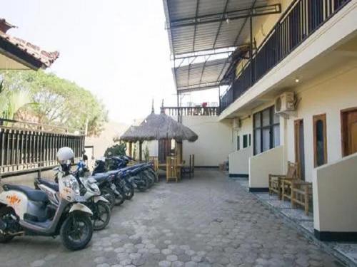 eine Reihe von Motorrädern, die neben einem Gebäude geparkt sind in der Unterkunft MURSYS PLACE in Kuta Lombok