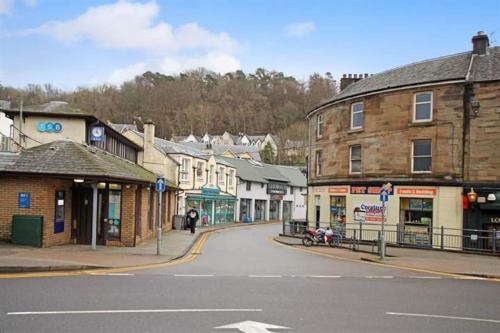 an empty street in a small town with buildings at The Creek-Stone Den in Oban