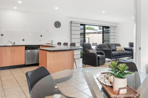 a kitchen and living room with a table and chairs at 4-21 Maple Lane in Evans Head