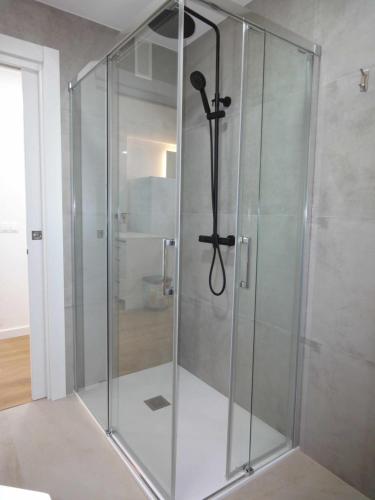 um chuveiro com uma porta de vidro na casa de banho em Somo. A pie de playa em Somo