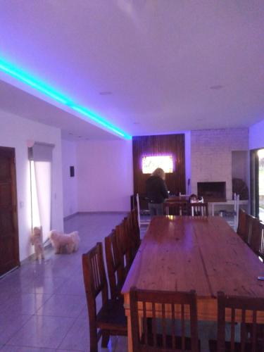 聖卡洛斯玻利瓦爾的住宿－Quinta con pileta，用餐室设有一张大木桌和一只狗