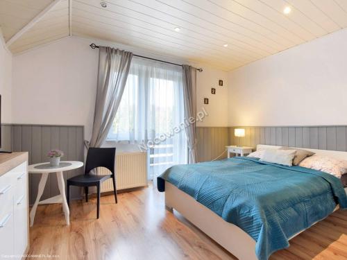1 dormitorio con cama, escritorio y ventana en Willa Bumerang & SKI en Karpacz