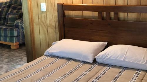 a bed with two pillows on top of it at Tarra Valley Retreat in Tarra Valley
