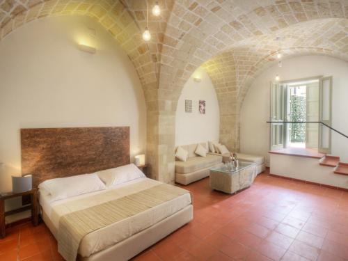 sypialnia z łóżkiem i kanapą w pokoju w obiekcie Miro B&B w mieście Lecce