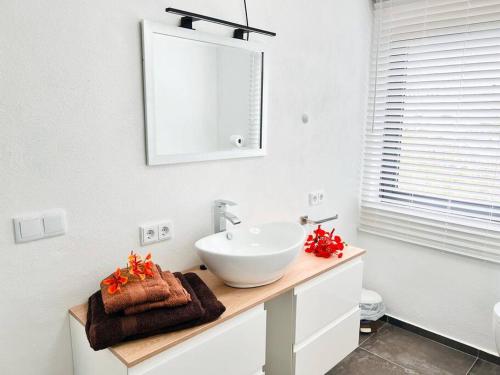 a white bathroom with a sink and a mirror at NEU!!! Apartment im Luxory Resort Coral Estate in Willibrordus