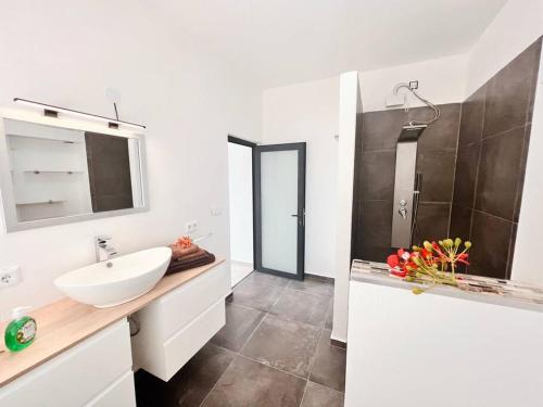 a white bathroom with a sink and a mirror at NEU!!! Apartment im Luxory Resort Coral Estate in Willibrordus