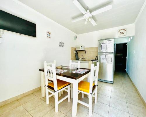 cocina con mesa, sillas y nevera en Beva's home Chajari en Chajarí