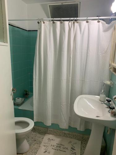 baño con cortina de ducha blanca y lavamanos en Rinconcito en San Salvador de Jujuy