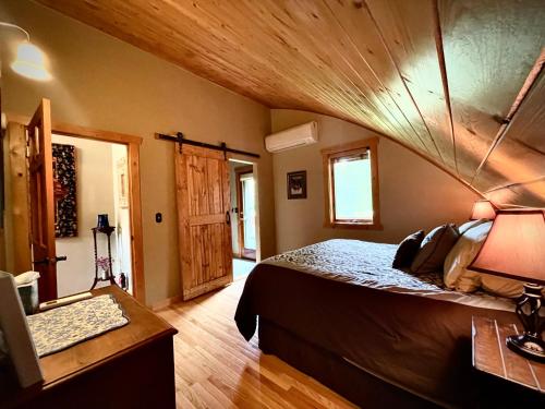 a bedroom with a bed and a wooden ceiling at Moss Mountain Inn in Columbia Falls