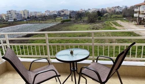 d'une table et de deux chaises sur un balcon avec vue. dans l'établissement Raise Mirivili Serviced Apartment, à Alexandroúpolis