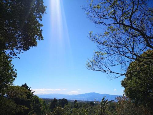 a beam of light in a blue sky with trees at Casa del Eucalipto in Sabana Redonda
